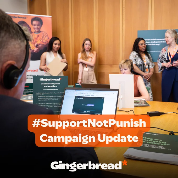A group of women stands in a conference room, engaged in discussion. One woman is sitting at a table, looking at a laptop, while another speaks with her back to the camera. The room features promotional materials for Gingerbread's #SupportNotPunish campaign, highlighting updates on the initiative.