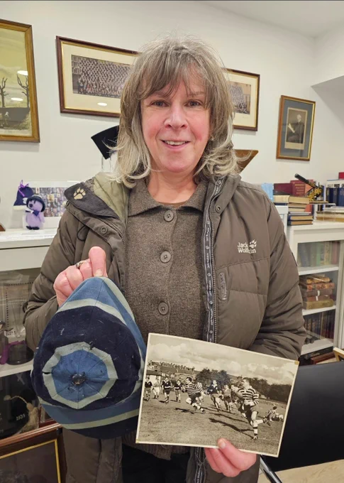 Carol with her late father Colin's cap and photo of him with his fellow team members playing Rugby