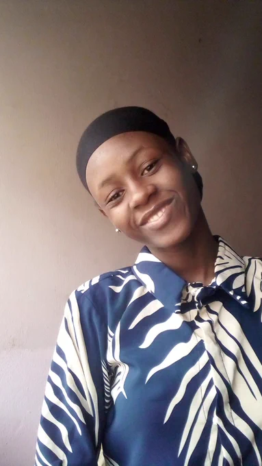 Ore in a black scarf and a patterned butter-coloured and navy blue shirt.
Smiling at the close-up view of the camera, the image is set in an indoor setting with a pink background. 


814 characters left

799 characters left
