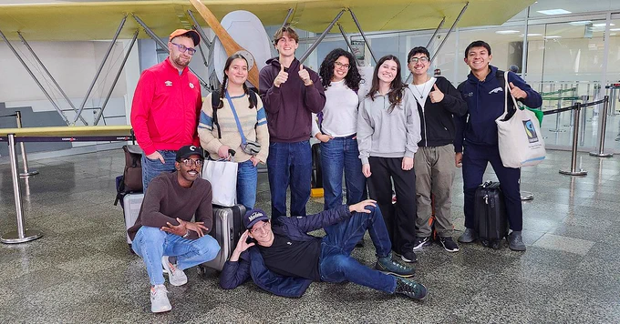A group of people pose in an airport.