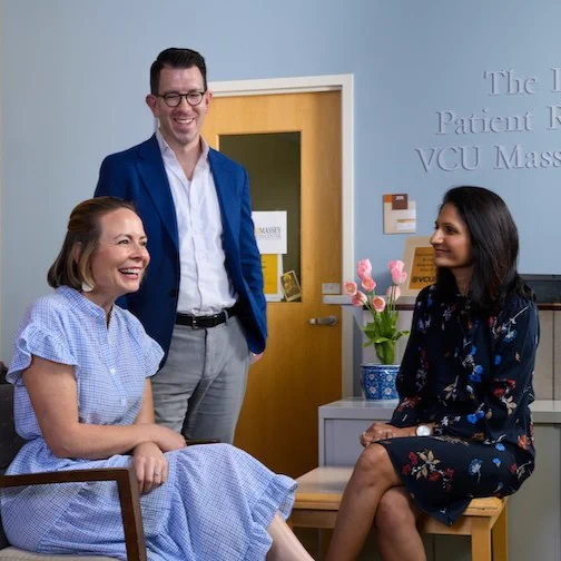 Patient and two healthcare workers sit and discuss patients care. 