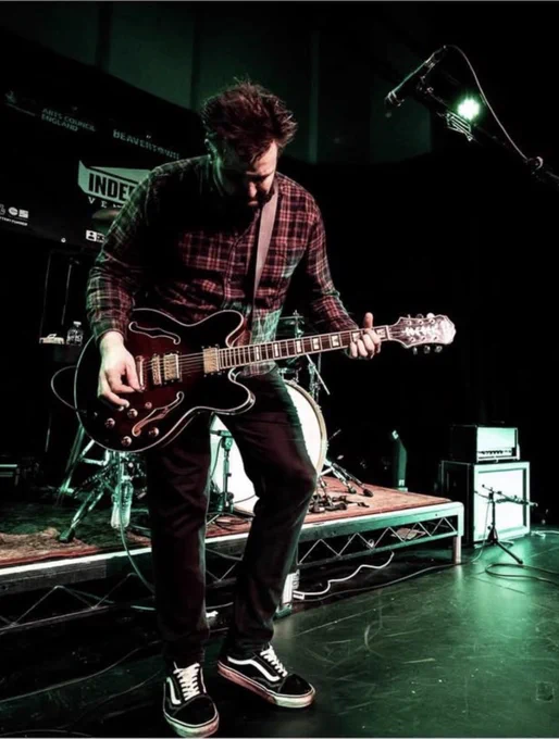 An image of me, playing guitar on stage with my band.