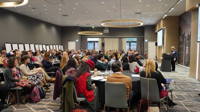 Full room of attendees with Dr Vicki Day on stage