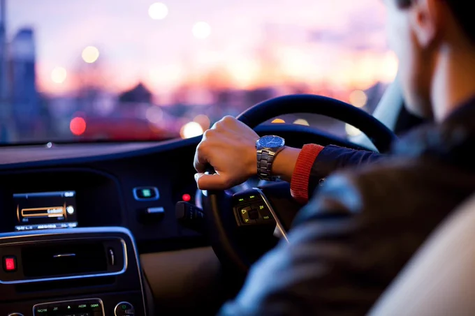 A person in a car, driving. 