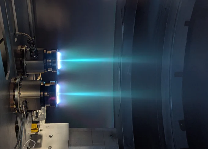 Two xenon thrusters firing in a chamber