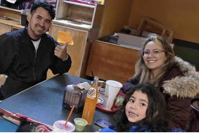 Photo of 7 year old Diana Crespo with her parents at a table in a restaurant