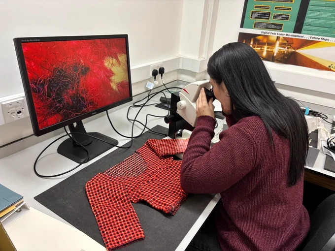 Prize Papers Project Conservator Marina Casagrande carrying out microscopic analysis of the fibres in the Faroese sweater, the now famous knitted "Regency sweater" or jumper from 1807 uncovered in 2024. A panel of speakers will discuss their interdisciplinary research at the Knitting History Forum Conference on Saturday 6th February. Photo credit: The National Archives