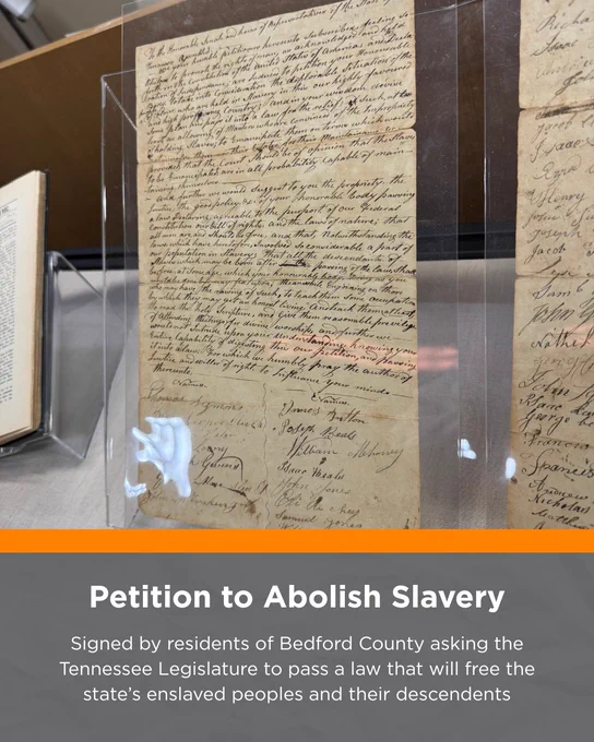 Handwritten petition to abolish slavery displayed in a protective case.