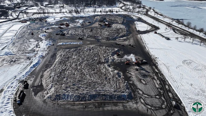 An overhead photograph of the Orchard Beach snow melting operation, including multiple melters, snow moving vehicles and very large piles of snow.