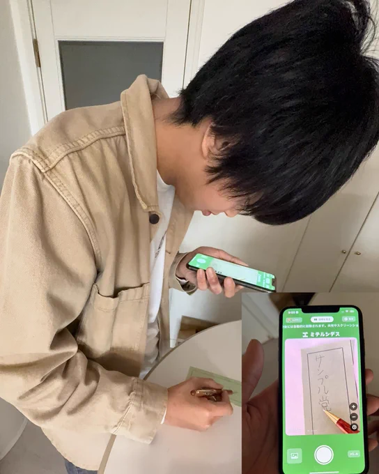 スマホで拡大しながらボールペンで画用紙にサンプル党と書いている様子。