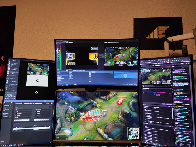 Photo of what's happening on my monitors while I'm running the livestream.

Left monitor (vertical): top half Discord with casters, bottom half League Broadcast
Upper middle monitor: OBS
Lower middle monitor: the actual LoL game
Right monitor (vertical): Twitch mod view

The background has a Münster Esports displate