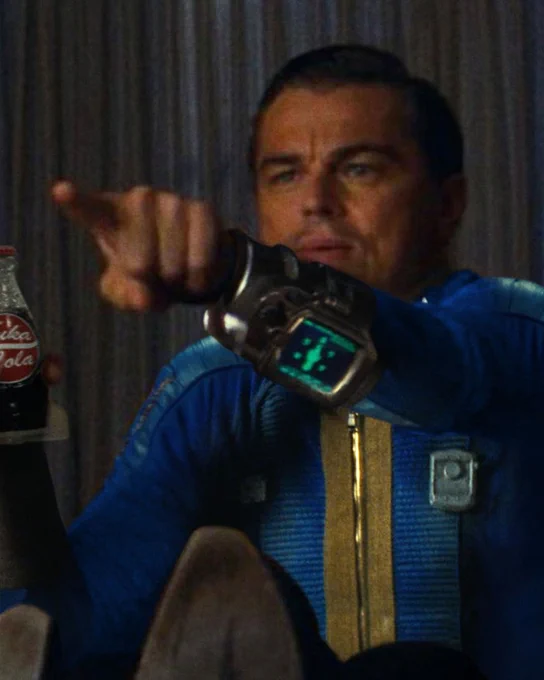 An edit of the famous Leonardo DiCaprio pointing meme, where he wears a vault suit, a Pip-Boy and is drinking a Nuka-Cola.