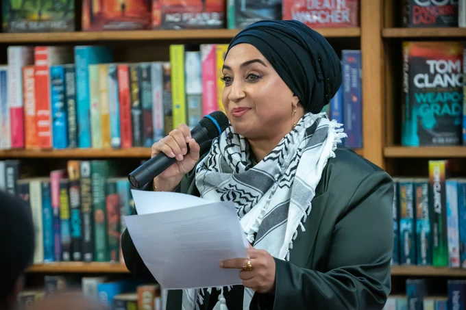 Woman reading poetry, holding a microphone 