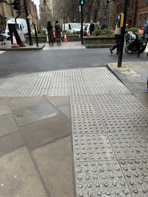 Grey tactile paving at what is clearly a signalised crossings.