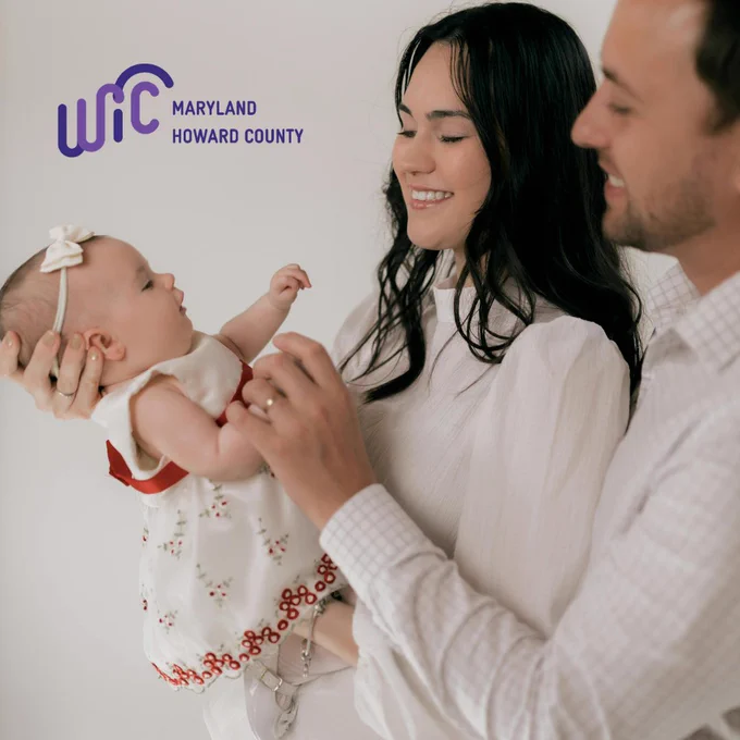 A mom and dad holds a baby. 