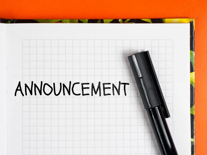 Black marker pen resting on a grid notebook page with the word 'ANNOUNCEMENT' written in bold letters.