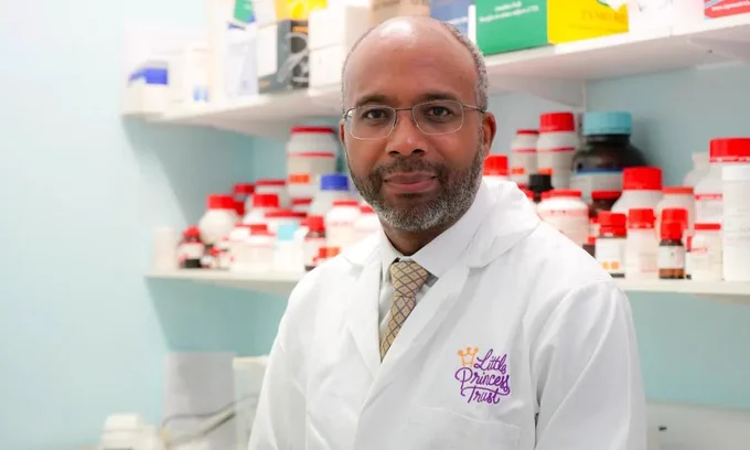 Amos Burke wearing a white lab coat.