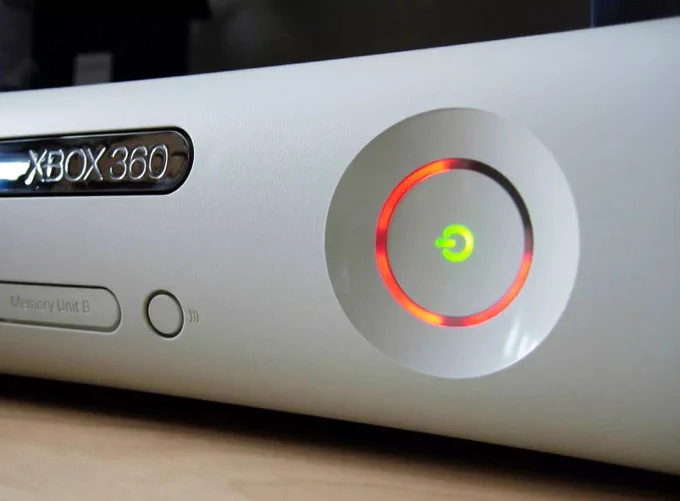 Close-up of an Xbox 360 console with a red ring of light around the power button.