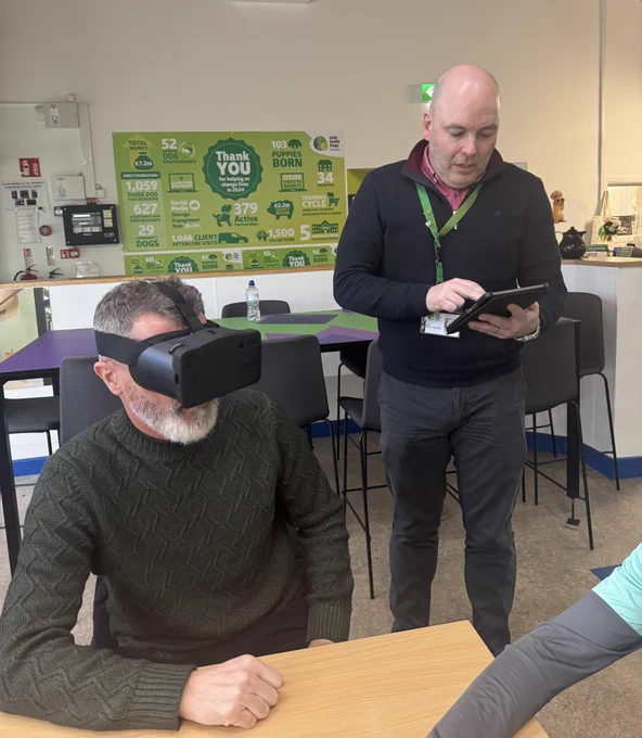 Roy Keane sitting at a table wearing the Eyes Reality headset. 