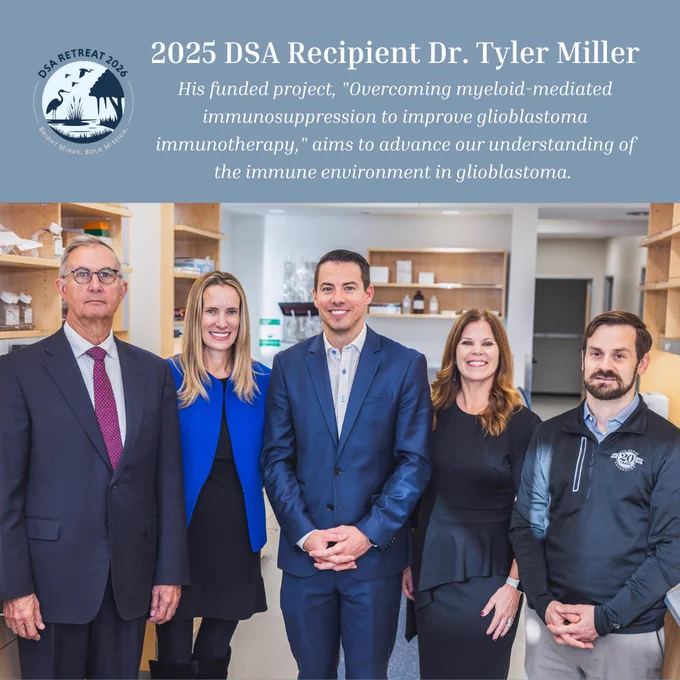 A group of five people stands together indoors, all looking at the camera. There is a banner above them that reads, "2025 DSA Recipient Dr. Tyler Miller. His funded project, 'Overcoming myeloid-mediated immunosuppression to improve glioblastoma immunotherapy,' aims to advance our understanding of the immune environment in glioblastoma." A logo at the top left corner indicates "DSA Retreat 2026."