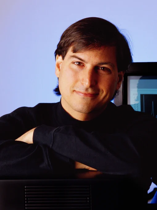 A photo of Steve smiling and looking directly into the camera, leaning forward on crossed arms.