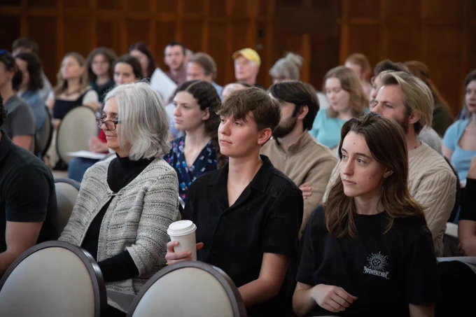 Faculty members and students in the audience listen in.