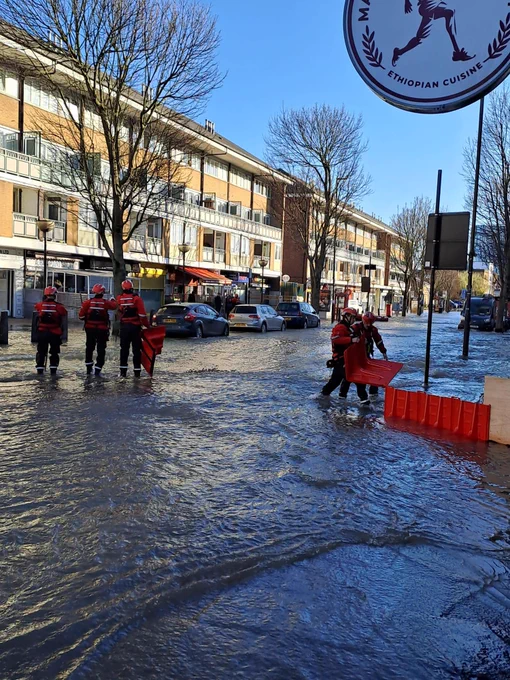 Three firefighters on the left, two on the right, carrying out responsibilities as Fire Rescue Unit crews at a flooding incident.