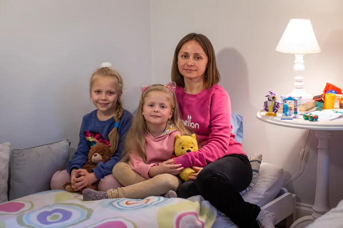 A mother and her two daughters in the room they all share.
