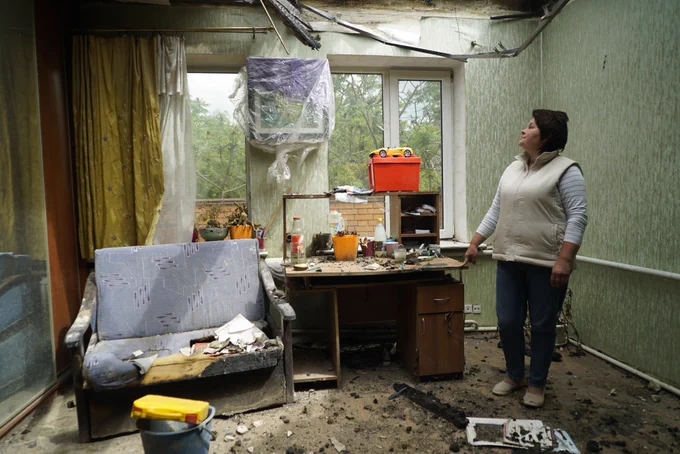 vanna Vasylykha standing in the ruins of her home in Kharkiv. The house was hit by a shell and caught fire, destroying parts of the roof. Now homeless, Ivanna is sheltering with friends in their flat nearby.
