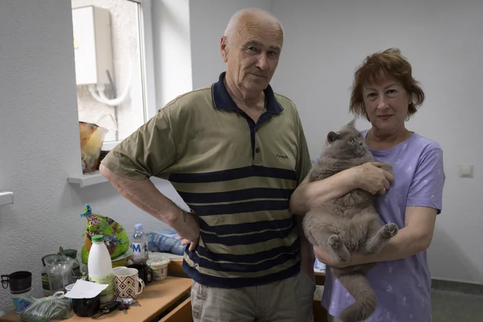 Ukrainian refugees, Igor and his wife Olga, pose with their cat, Lux, at a refugee center in central Moldova on August 11th 2022.
