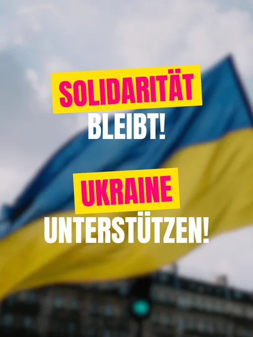 Ein Plakat mit dem Aufdruck "Solidarität bleibt! Ukraine unterstützen!" vor einer ukrainischen Flagge.