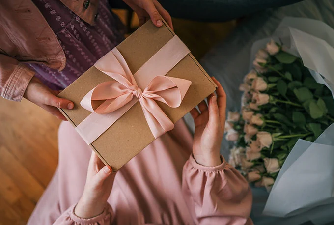Overhead photograph of someone gifting a present. 