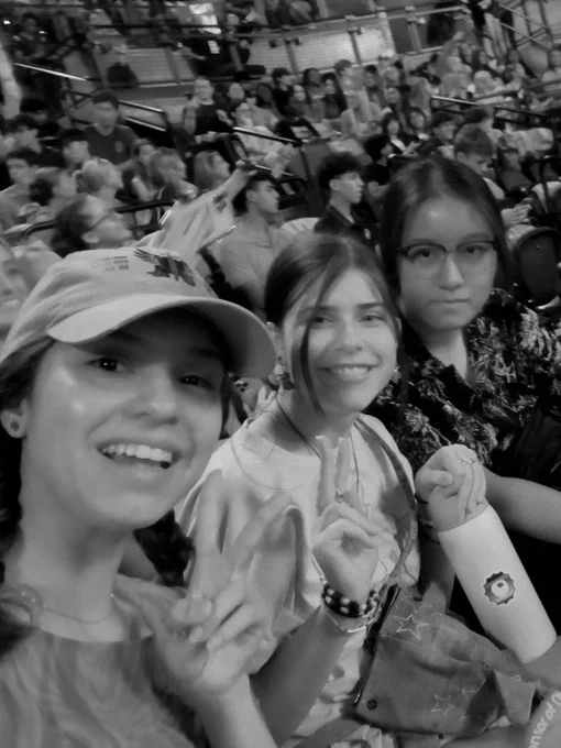Three people taking selfie in arena setting.