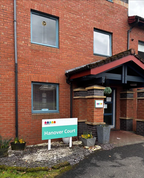 Entrance door to a sheltered housing complex. There is a sign to the left hand side saying Hannover court