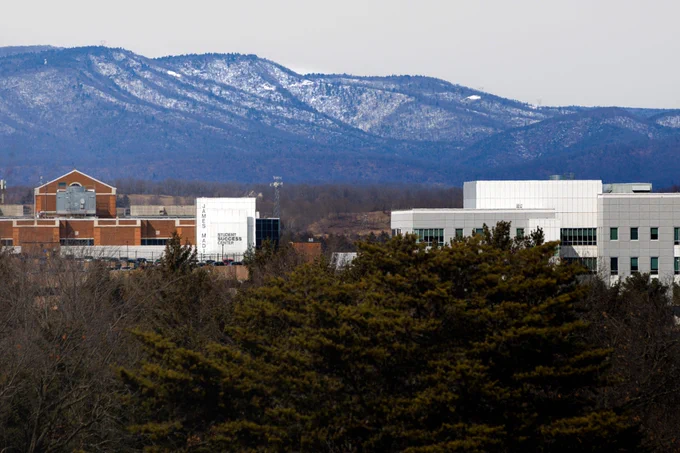 The JMU Student Success Center and CHBS building stand against distant blue ridge mountains.