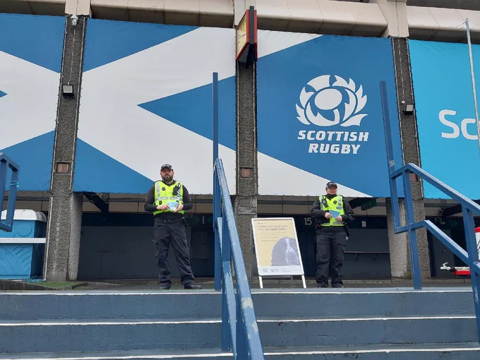 Project Servator officers were deployed to Murrayfield Stadium ahead of Six Nations Rugby game this weekend. Image shows two uniformed officers outside the Scottish Rugby Stadium with a Project Servator information sign.