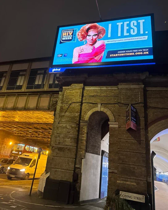 Billboard with a drag queen on it. Message reads 'I Test'.