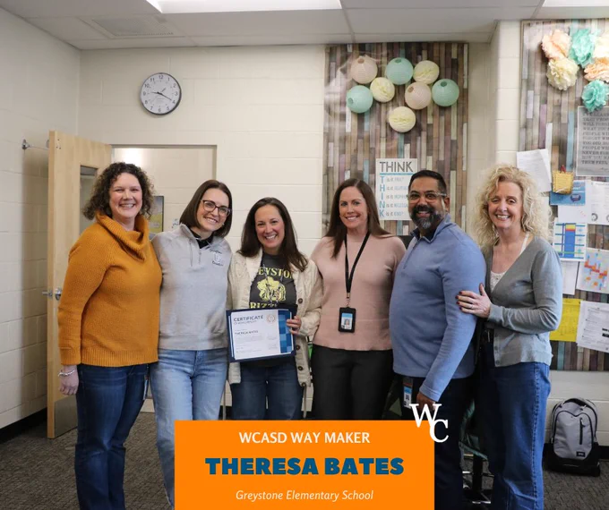 Six educators stand together in a classroom celebrating Theresa Bates receiving a Way Maker certificate at Greystone Elementary School.