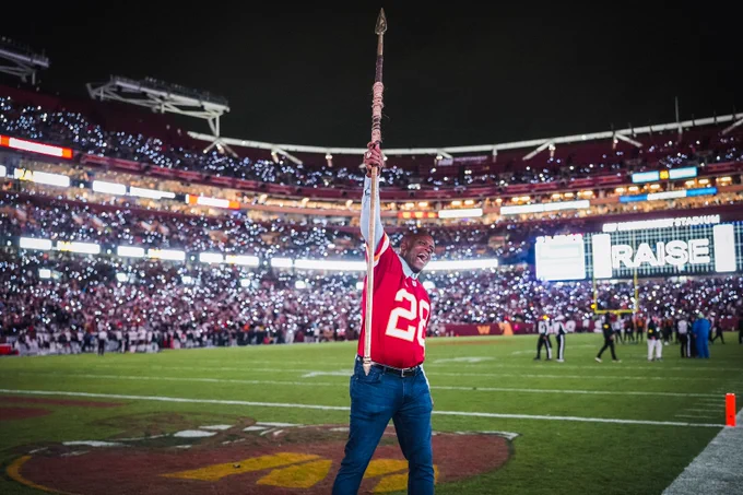 Photo of Darrell Green holding a spear at a Commanders game.