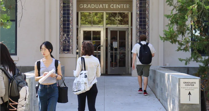 Grad students walking to and from the north entrance of the Graduate Center at Walker Hall.