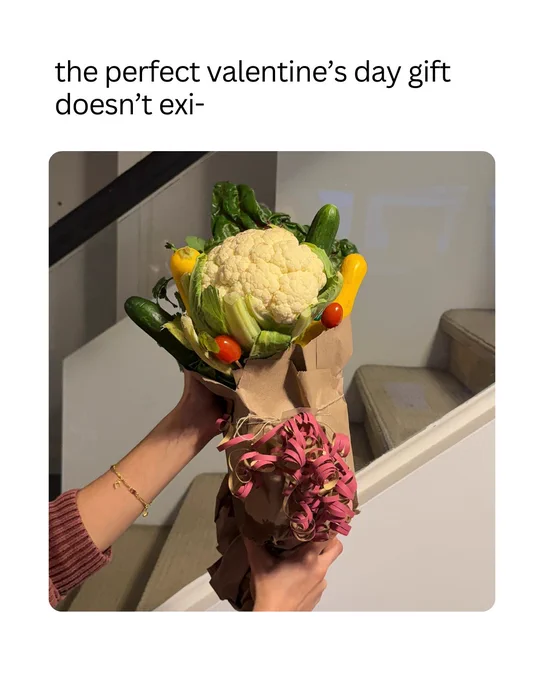 A person holds a bouquet made of vegetables, including a cauliflower, cherry tomatoes, small bell peppers, and greens. Text above reads, "the perfect valentine's day gift doesn't exi-".