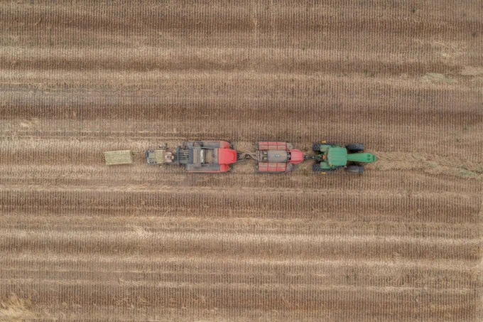 Aerial view of a tractor pulling farming equipment across a large, freshly plowed field. AgriFutures is seeking a service provider to develop an alternative ARGT test for the export fodder industry, improving efficiency and reducing costs. 