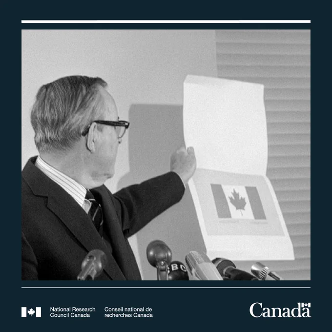 Prime Minister Lester B. Pearson holding an illustration of the new Canadian flag at a press conference in December 1964.
