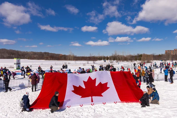 Giant Canadian flag held by members of the public at the Gatineau Loppet.