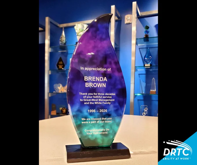 Tall glass award with purple and teal gradient honoring Brenda Brown for 30 years of service from 1996 to 2026, congratulating her retirement.