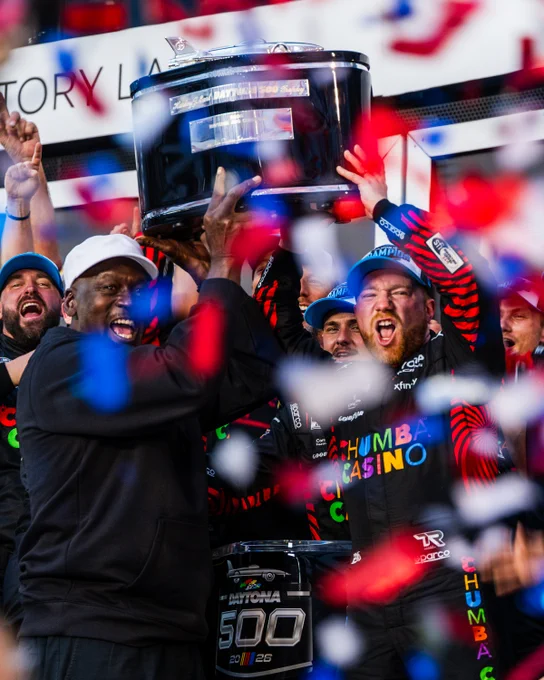 A photo of Michael Jordan and Tyler Reddick hoisting the Harley J. Earl Trophy at Daytona International Speedway.