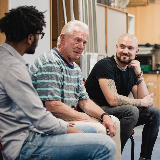 Group of men sitting in a circle having a coversation