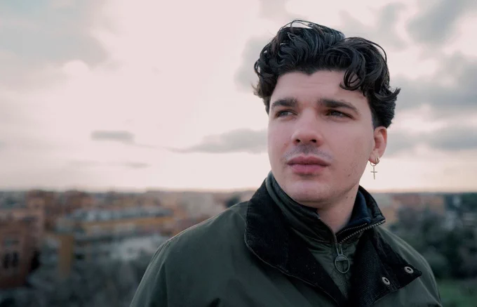 Close-up of Harry Clark stood in a city. A blurred skyline fills the background. 