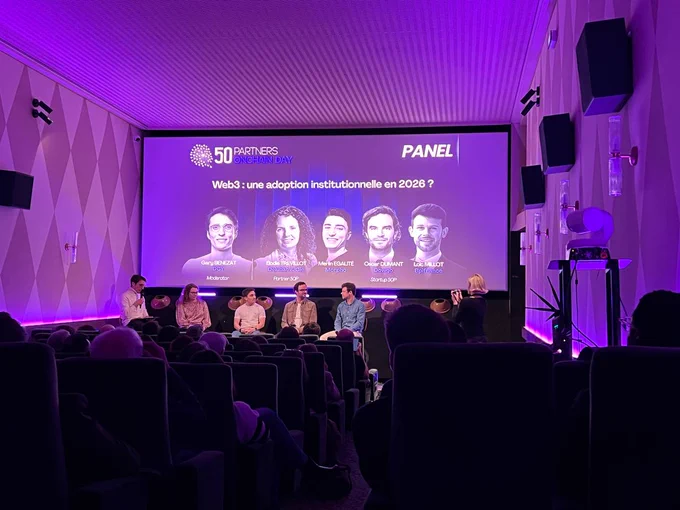 A panel discussion at an event showcasing industry leaders discussing Web3 adoption, with an engaged audience in a stylish setting.