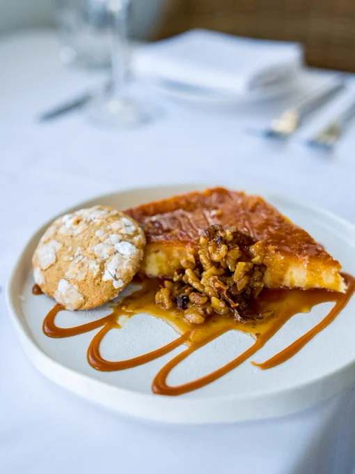 A plate food sits on a white table cloth.